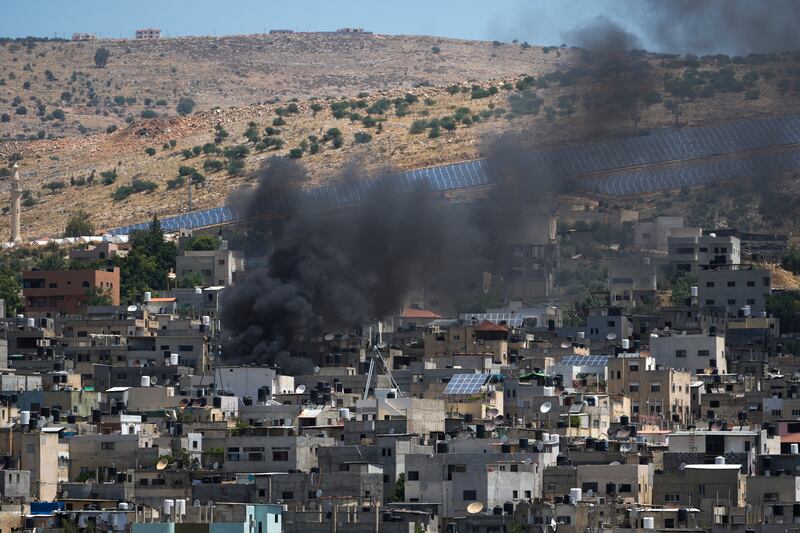 Smoke rises in the Palestinians Al Fara’a refugee camp in the occupied West Bank following an Israeli military raid (Majdi Mohammed/AP)