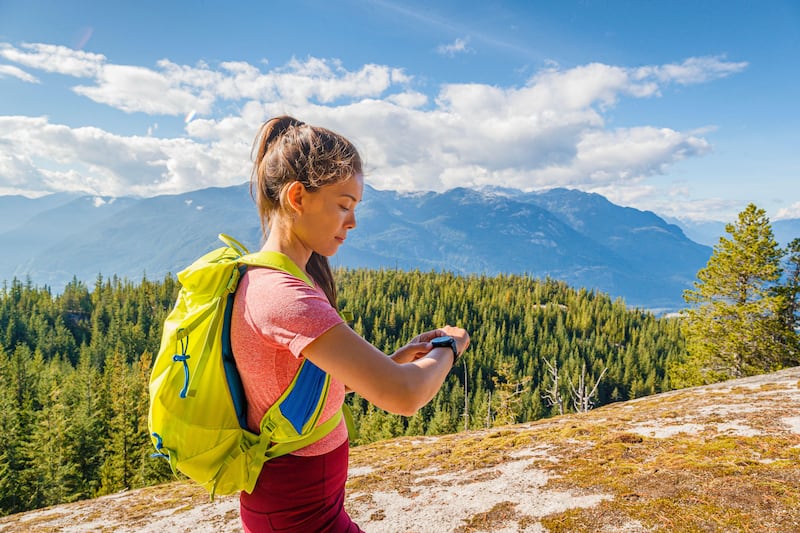 A female hiker checking her fitness tracker