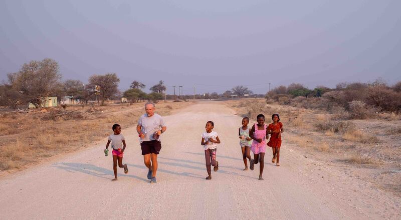 Keith Boyd, 57, running with children in Africa as he attempts to break the world record for fastest person to run the length of the continent (Rainbow Leaders)
