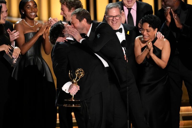 Matty Matheson, centre, and Ebon Moss-Bachrach kiss as The Bear wins the award for outstanding comedy series during the 75th Primetime Emmy Awards (Chris Pizzello/AP)