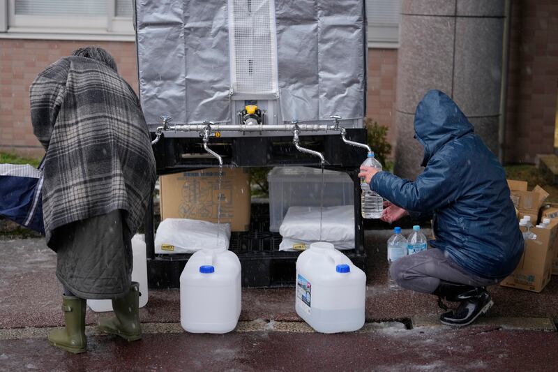 Evacuees from a deadly earthquake receive water supplies (Hiro Komae/AP)