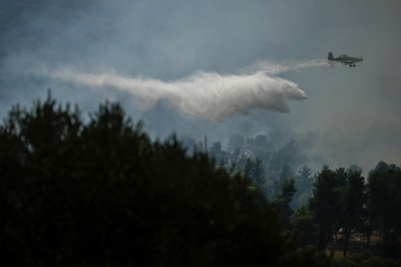 An Israeli firefighter plane above an open area near the city of Safed, northern Israel (Leo Correa/AP)