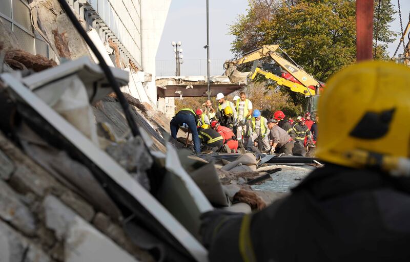 Rescue service staff work at the scene of the collapse