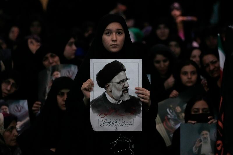 A woman holds a poster of the late Iranian President Ebrahim Raisi at Mam Khomeini Grand Mosque in Tehran (Vahid Salemi/AP)