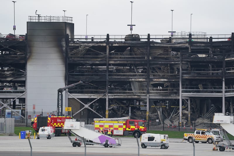 The burned out shells of cars buried amid debris at the multi-storey car park at Luton Airport