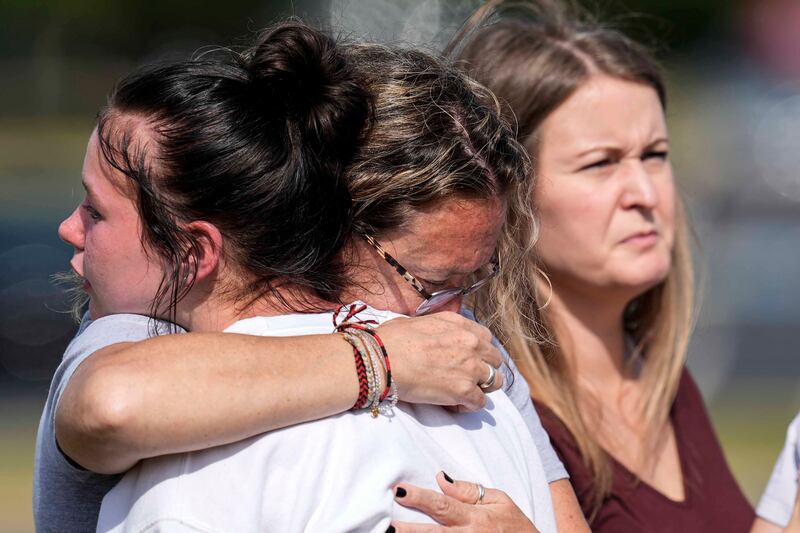 People embrace at a makeshift memorial after the shooting at Apalachee High School in Winder, Georgia (AP Photo/Mike Stewart)