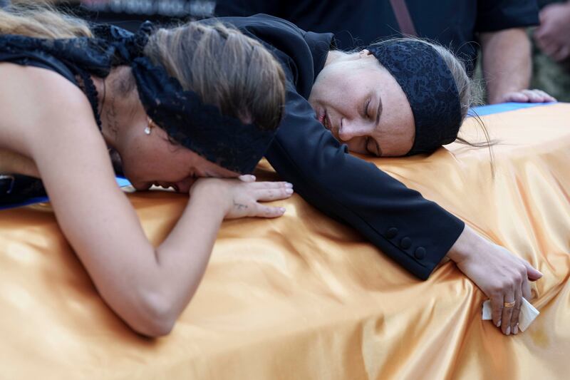 Relatives cry over the coffin at the funeral in Poltava of a Ukrainian serviceman killed in a Russian rocket attack on a military academy (Evgeniy Maloletka/AP)