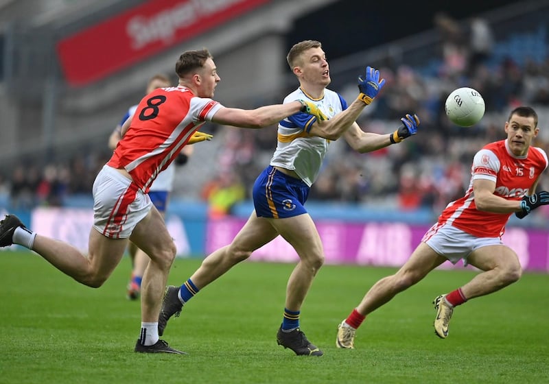 Peadar O Cofaigh Byrne and Con O'Callaghan of Cuala close in on Errigal Ciaran midfielder Ben McDonnell.