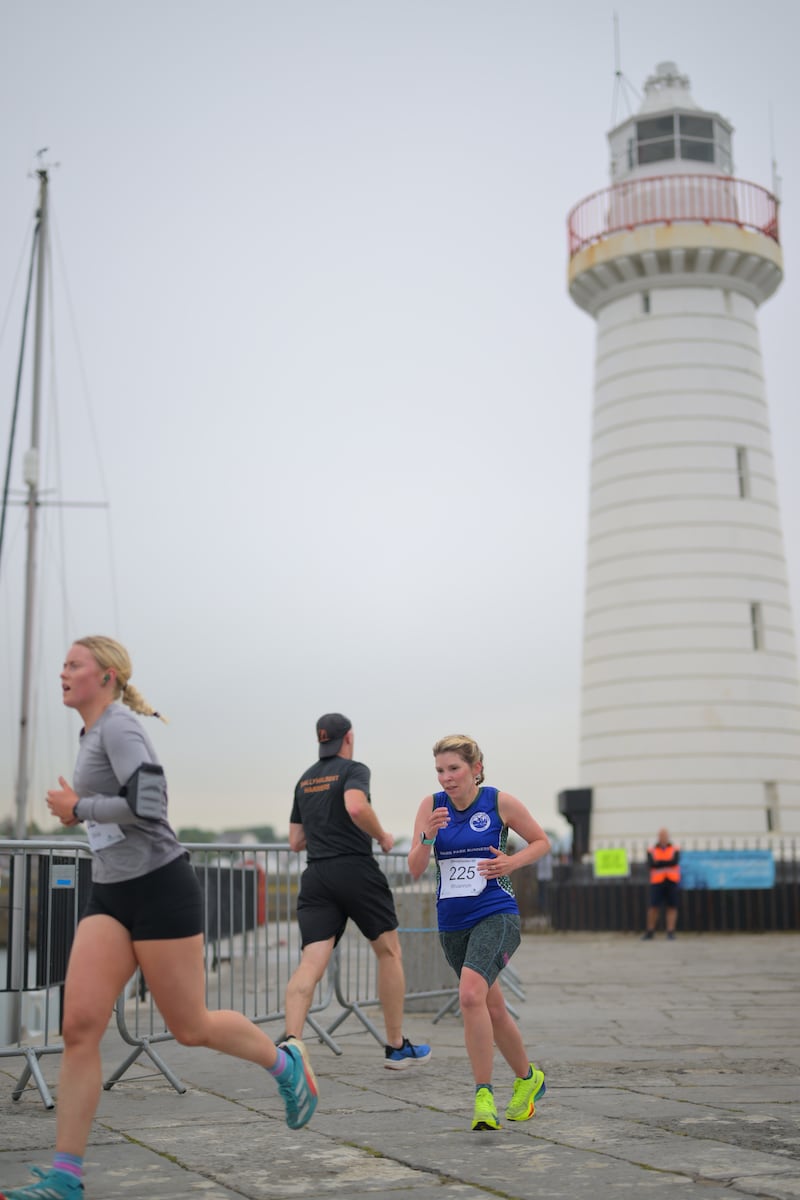 Group of runners in 5k race in front of white lighthouse