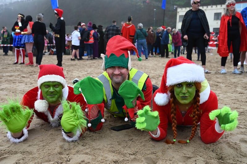 People take part in the annual Tenby Boxing Day swim dressed as superheroes