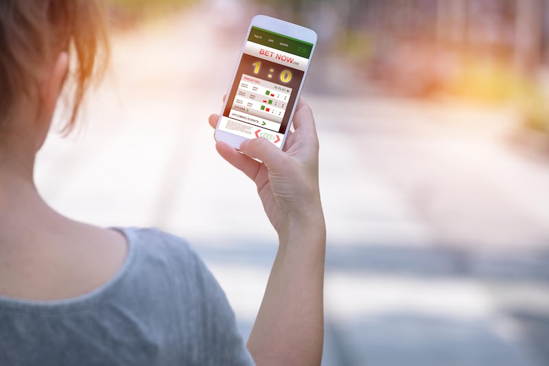 Close up photo of woman betting on a sports game on her phone