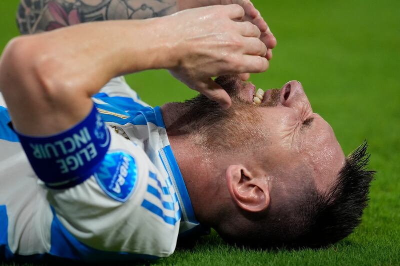 Argentina’s Lionel Messi grimaces in pain (Rebecca Blackwell/AP)