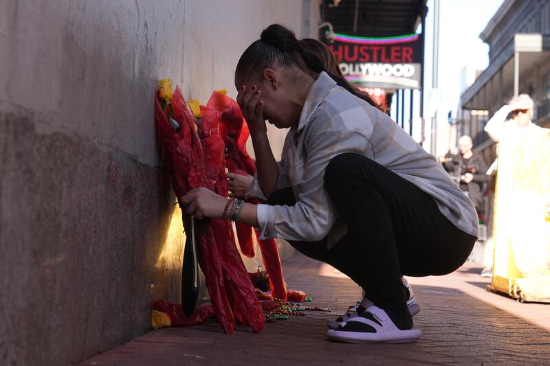 Samantha Petry places flowers at a memorial on Canal and Bourbon Street (George Walker IV/AP)