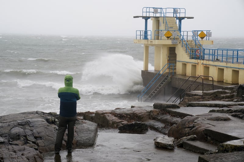 A person watches the waves in Salthill, Galway, as a Met Eireann orange alert came into effect at 10am for large parts of Ireland on Sunday