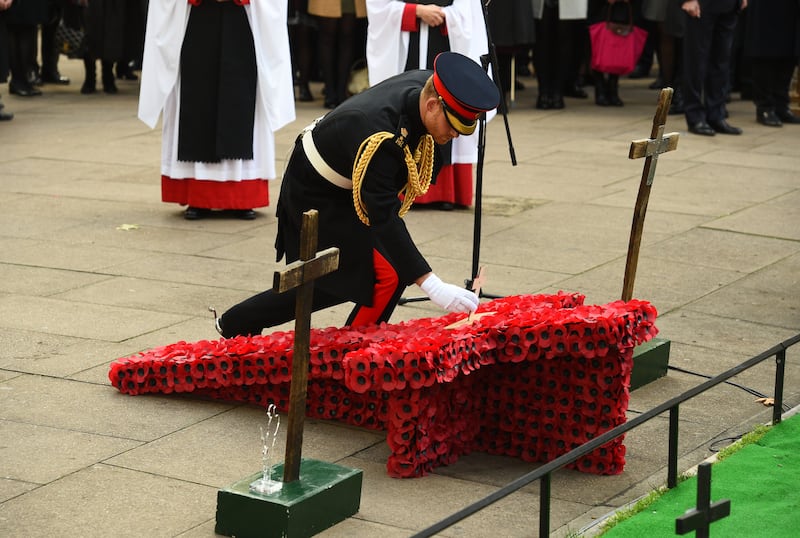 The Duke of Sussex places a cross on a memorial at the Field of Remembrance at Westminster Abbey in 2018