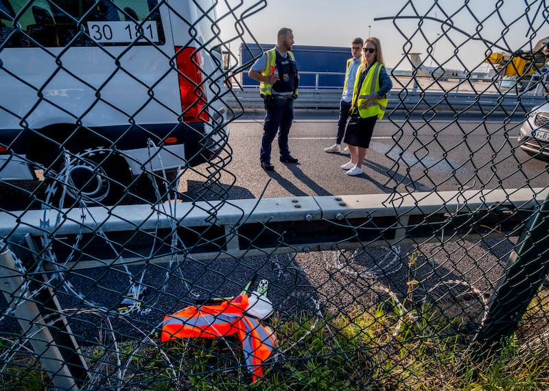 Police officers study the hole in the fence (Michael Probst/AP)