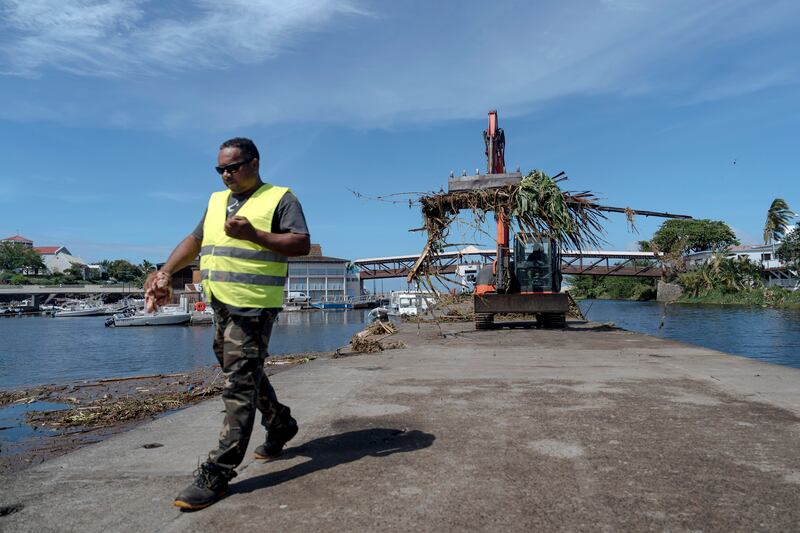 Workers clean up trees and debris on the marina of Saint-Gilles les Bains on the French Indian Ocean island of Reunion (Lewis Joly/AP)