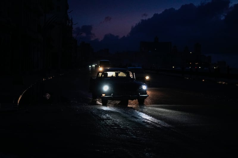 Vehicle headlights have been a source of light for many since the power cut (AP Photo/Ramon Espinosa)