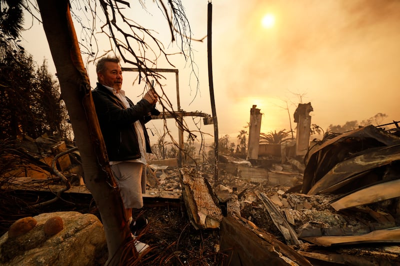 A resident looks at his home damaged by the Palisades fire in Malibu (Etienne Laurent/AP)