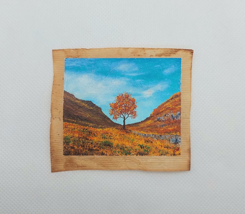 The Sycamore Gap tree painted during autumn on a used tea bag