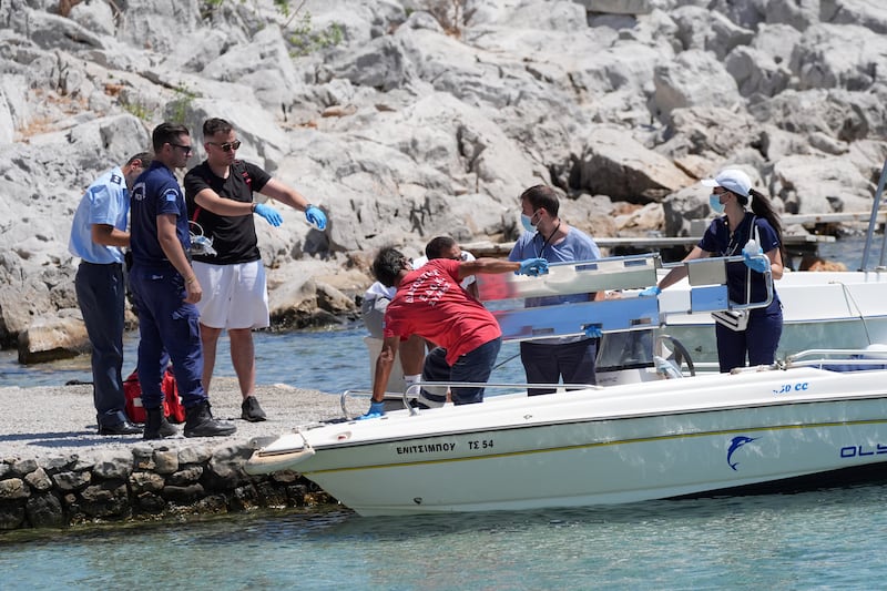 Emergency services lifting an empty stretcher from a boat at Agia Marina