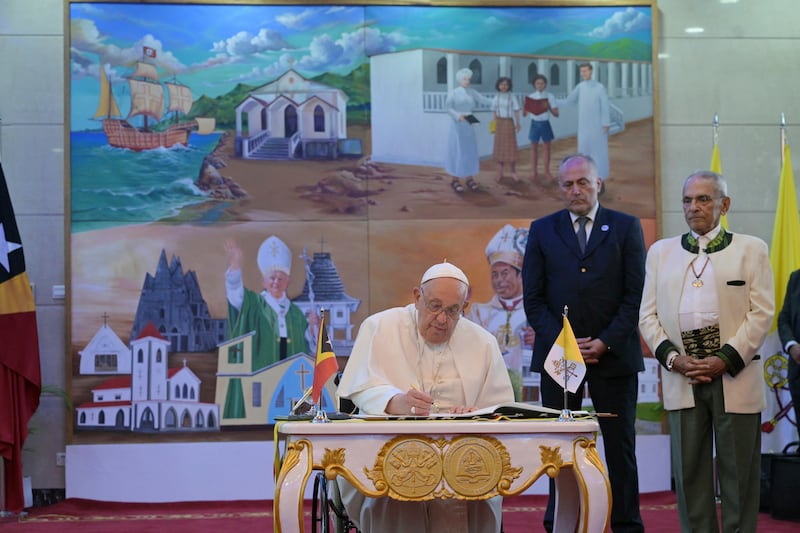 Pope Francis signs a guestbook as East Timor’s President Jose Ramos-Horta, right, looks on at the Presidential Palace in Dili, East Timor (Tiziana Fabi/Pool Photo via AP)