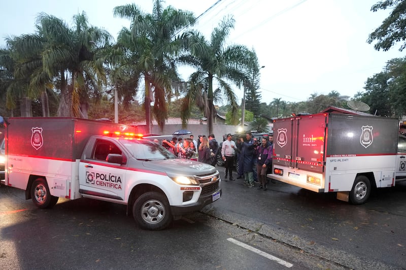 Police vehicles arrive at the gated community where a plane crashed in Vinhedo, Sao Paulo state, Brazil (Andre Penner/AP)