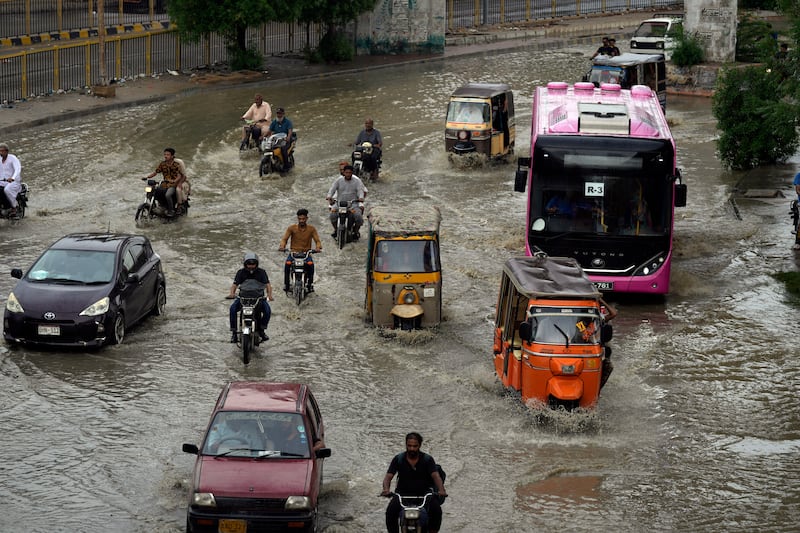 Vehicles drive through a flooded road caused by heavy monsoon rain in Karachi, Pakistan, on July 30 (Fareed Khan/AP)