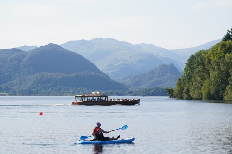 A paddle boarder goes out in the September sunshine