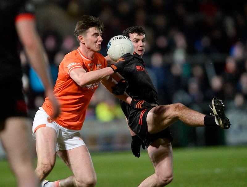 Ben Crealey closes in on Craig Lennon as Armagh edge Louth in Saturday night's League opener. Picture by Mark Marlow