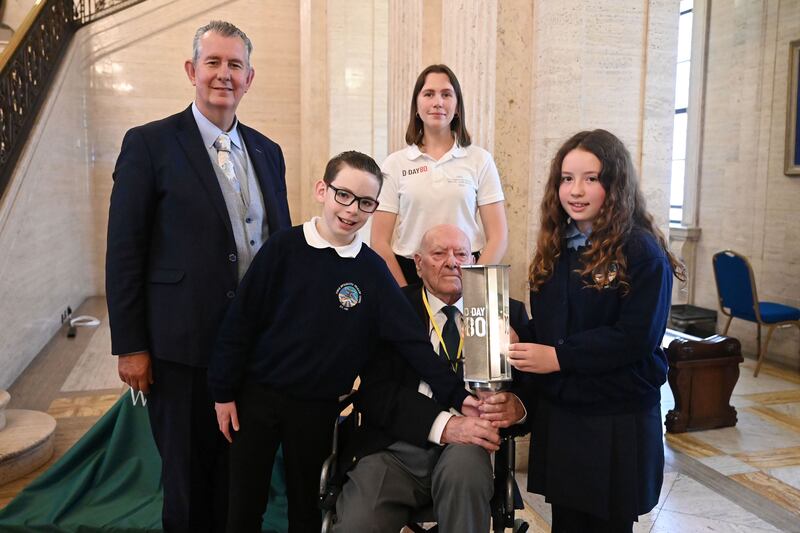 REPRO FREE
28/5/24: The Assembly Speaker, Edwin Poots MLA, hosted a ‘Lighting their Legacy’ event at Parliament Buildings to mark the 80th Anniversary of the D Day Landings.  The event took place as part of the Commonwealth War Graves Commission’s Lighting Their Legacy programme. 

Pictured with The Assembly Speaker, Edwin Poots MLA is George Horner, a veteran of the D-Day Landings, Megan Motley, Commonwealth War Graves Commission, Mason Spence and Sophie Aly from Forge Integrated Primary School with a beacon lit to symbolise the passing ‘of the torch’ from D Day veterans to a new generation. Picture: Michael Cooper