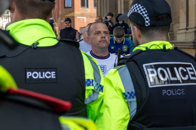 Roger Haywood stands in front of police