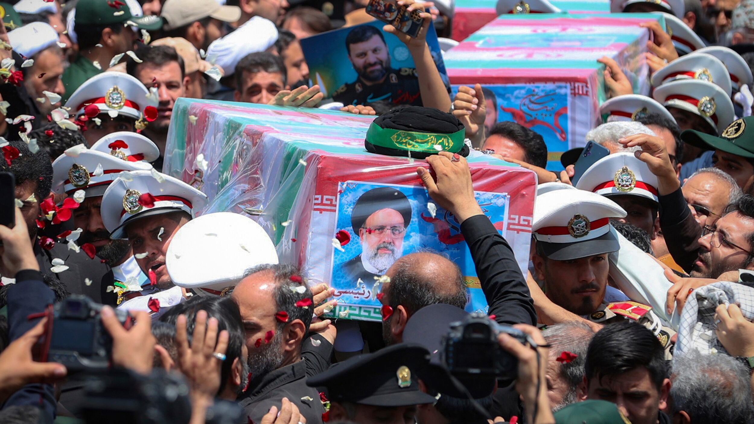 The flag-draped coffins of the late president Ebrahim Raisi and his companions who were killed in a helicopter crash on Sunday are carried during their funeral ceremony in the city of Mashhad, Iran (Iranian Presidency Office via AP)