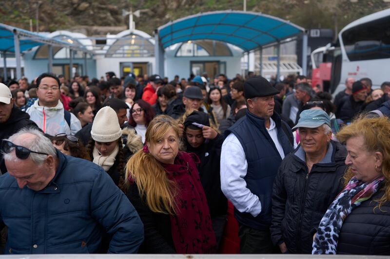 Passengers wait to board a ferry bound for the Greek mainland in the earthquake-struck island of Santorini, Greece (Petros Giannakouris/AP)