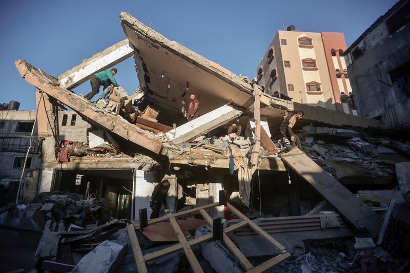 Palestinians inspect the damage of a destroyed house following Israeli air strikes on Khan Younis (AP)