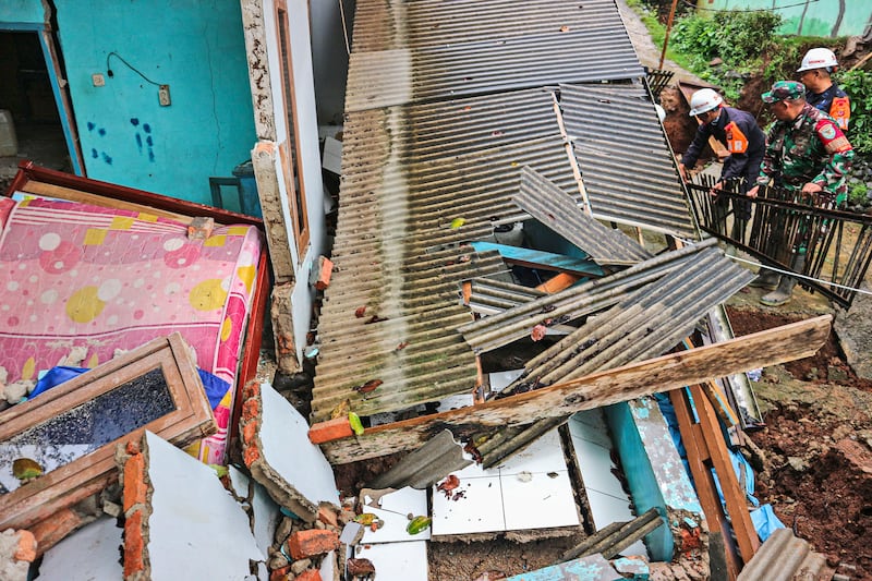 Rescuers clear up rubble from damaged houses at a neighbourhood affected by a landslide in Sukabumi, West Java, Indonesia (Rangga Firmansyah/AP)