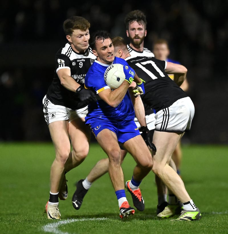 Errigal Ciaran's Darragh Canavan is challenged by two Clonoe opponents