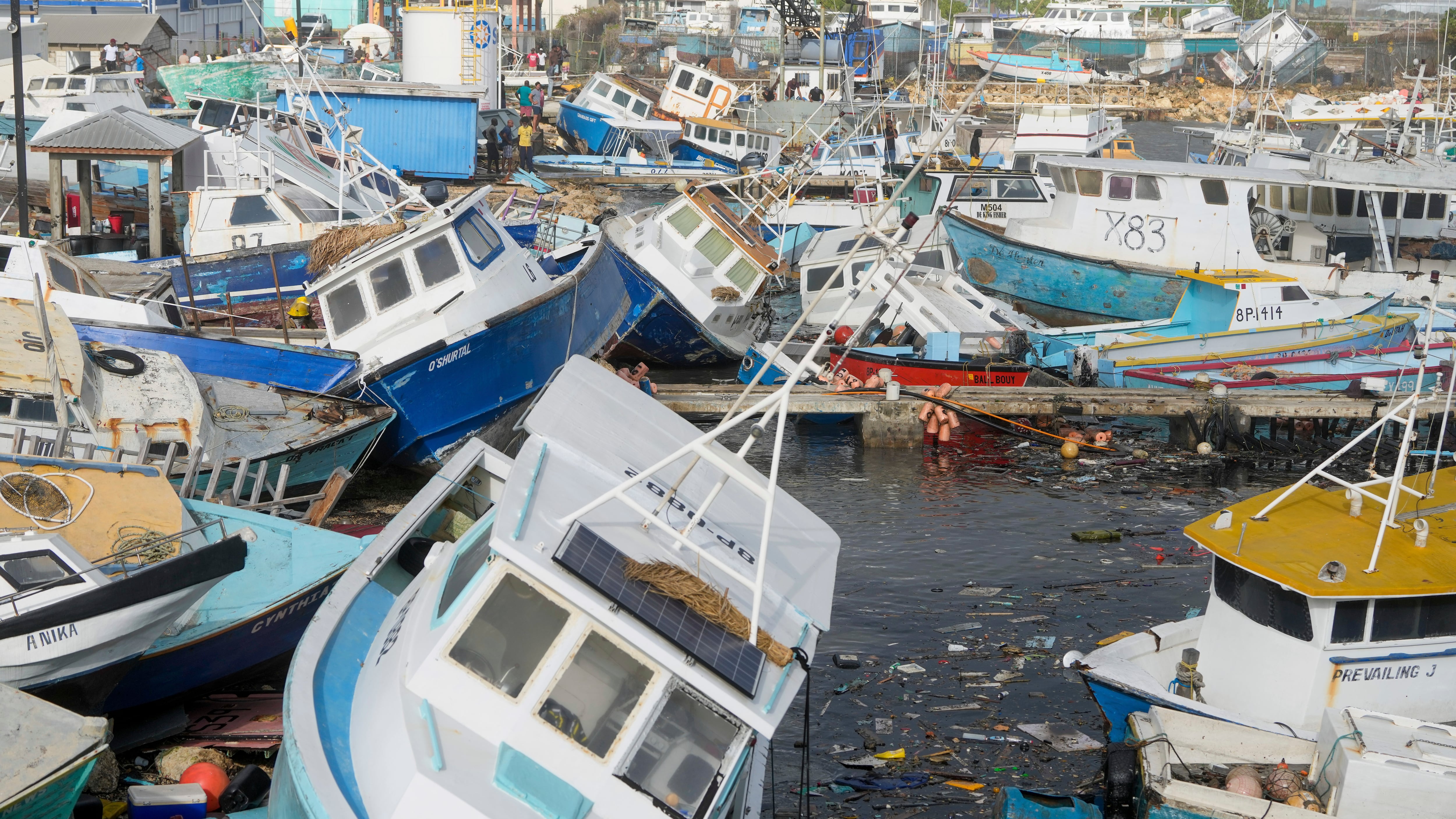 Fishing vessels damaged by Hurricane Beryl sit upended at the Bridgetown Fisheries in Barbados (Ricardo Mazalan/AP)