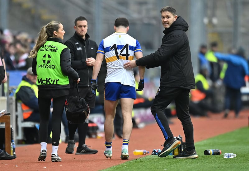 Darragh Canavan of Errigal Ciaran leaves the field with manager Enda McGinley after injury in the first half.