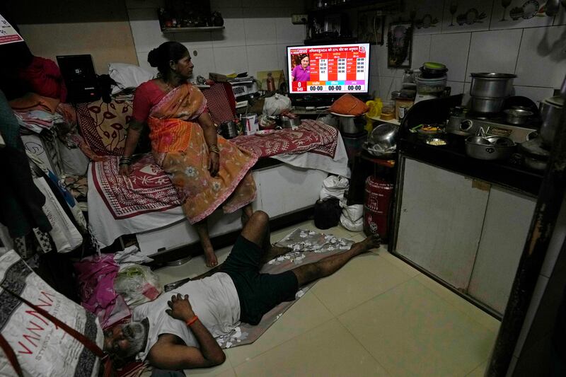 A woman watches an exit poll on television at her home in Mumbai, India (Rajanish Kakade/AP)