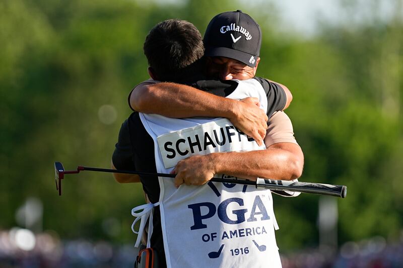 Xander Schauffele hugs his caddie Austin Kaiser after winning the US PGA Championship (Sue Ogrocki/AP)