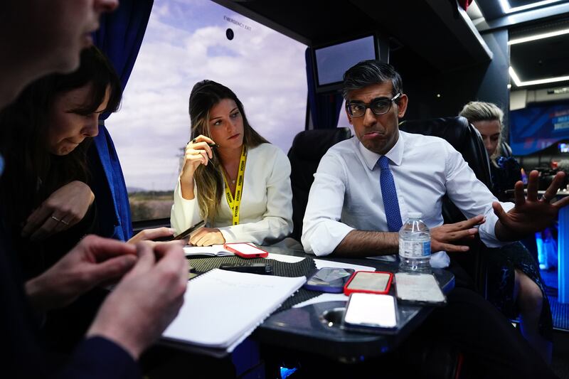 Prime Minister Rishi Sunak talks to journalists on board his campaign battle bus during the election campaign