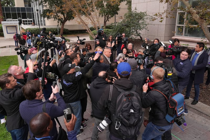 The media surround family members of Erik and Lyle Menendez as they arrive at the courthouse (Jae C Hong/AP)