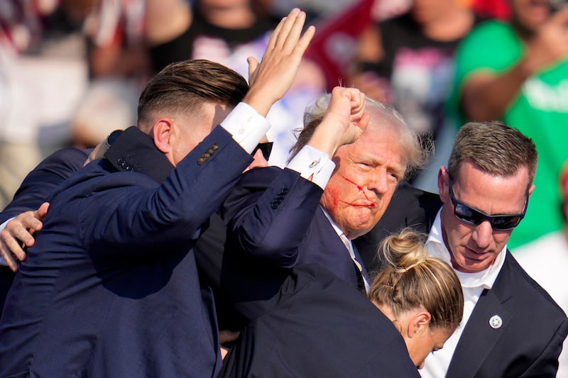 Donald Trump is helped off the stage by US Secret Service agents (Gene J. Puskar/AP)