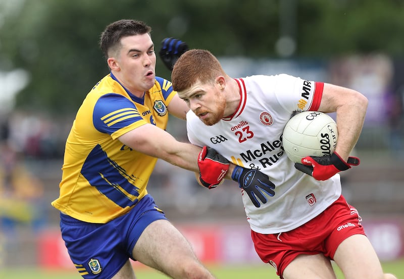 Tyrone's Cathal McShane is put under pressure by a Roscommon defender.