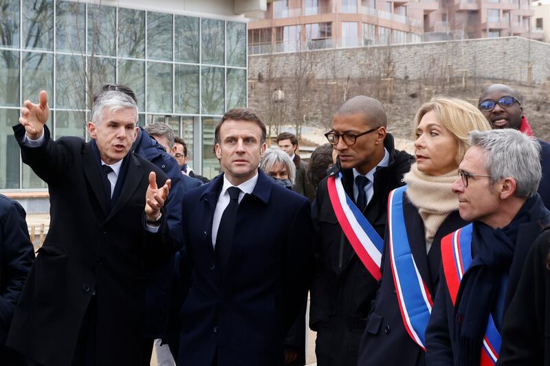 France’s President Emmanuel Macron is shown the Olympic village (Ludovic Marin, Pool via AP)