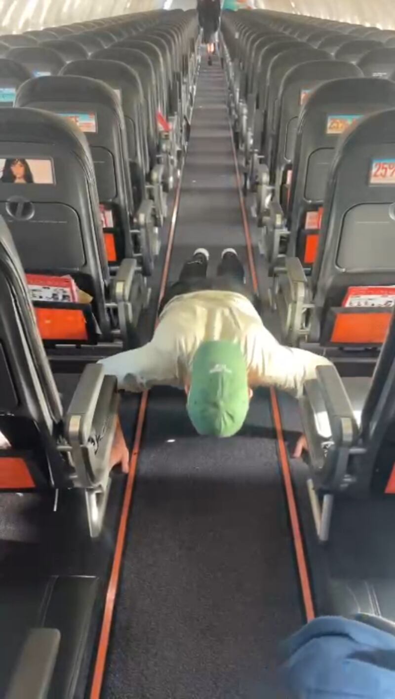 Alex Welford completing his press-ups on an aeroplane so he can reach his goal of 100,000 press-ups over the year (Alex Welford)