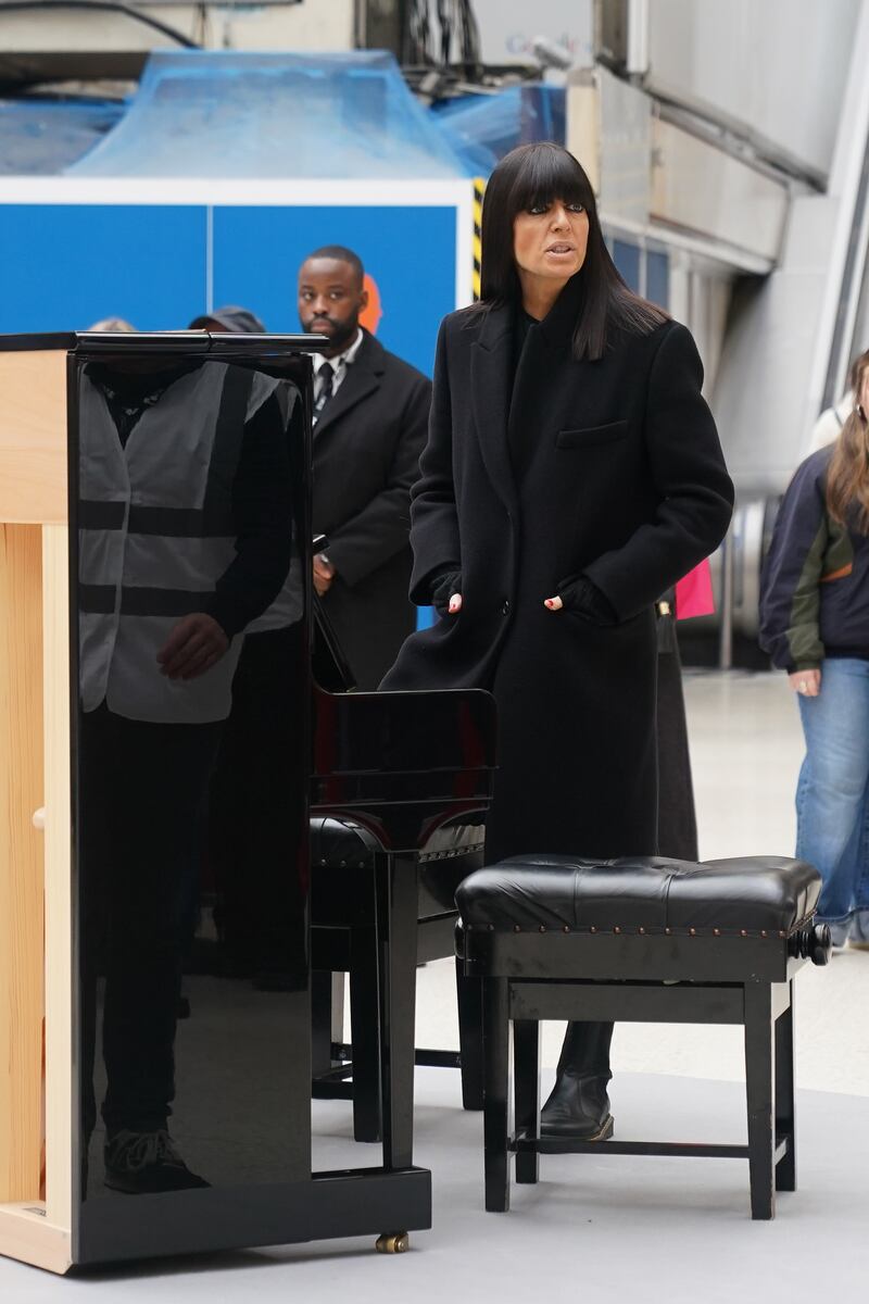 Claudia Winkleman next to a piano