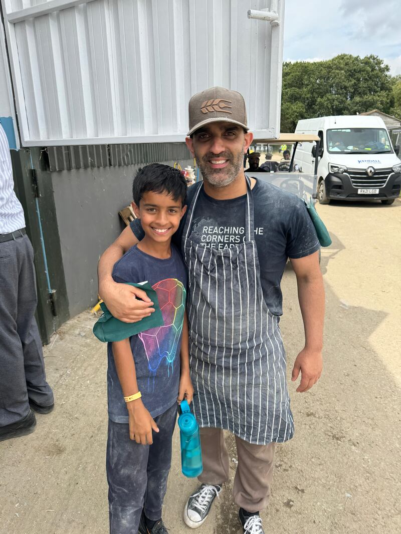 Faraz Sethi with his son, Zachariah Sethi, outside the on-site roti plant at the Jalsa Salana