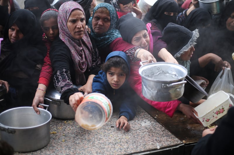 Palestinians line up for free food distribution during the ongoing Israeli air and ground offensive in Khan Younis, Gaza Strip (Hatem Ali/AP)